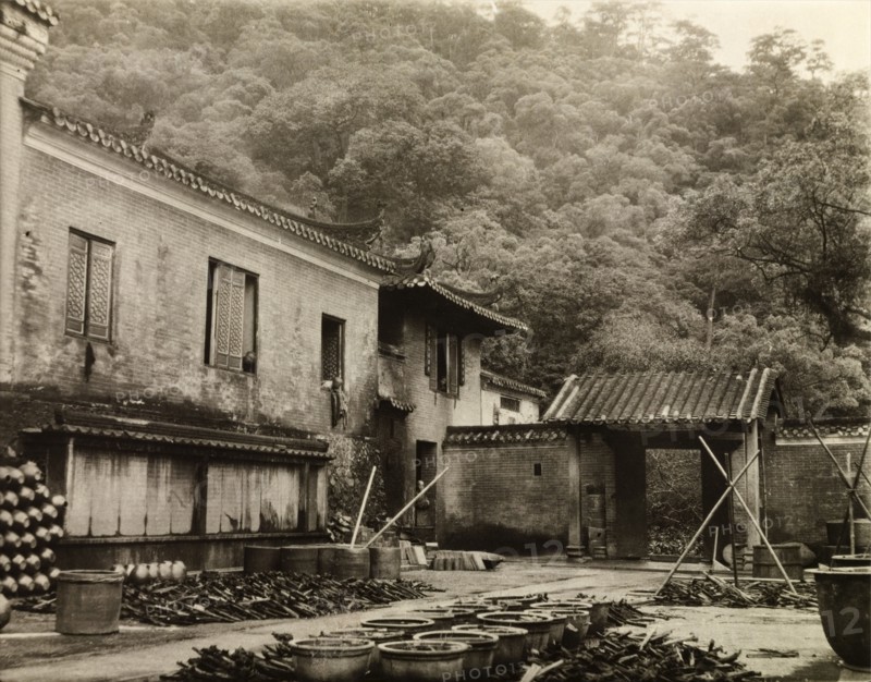Woodyard at a Guangdong monastery. A woodyard, located at the rear of a hillside monastery, is filled with piles of chopped wood and rows of containers. Canton Province (Guangdong), China, circa 1906., Guangdong, China, People's Republic of, Eastern Asia, Asia.