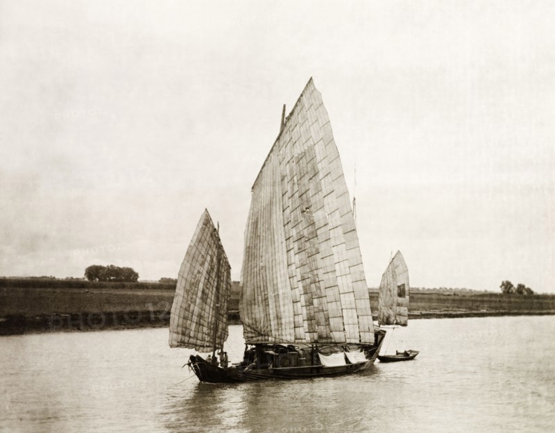 A junk transports salt on the Yangtze River. A Chinese junk with sails made from woven bamboo, transports salts on the Yangtze River. China, circa 1910. China, People's Republic of, Eastern Asia, Asia.