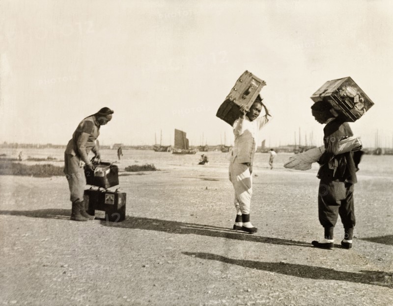 Luggage handlers at Newchwang port. Three luggage handlers prepare to load suitcases onto a waiting ferry at Newchwang (Yingkou) port. Newchwang (Yingkou), Liaoning Province, China, circa 1920. Yingkou, Liaoning, China, People's Republic of, Eastern Asia, Asia.