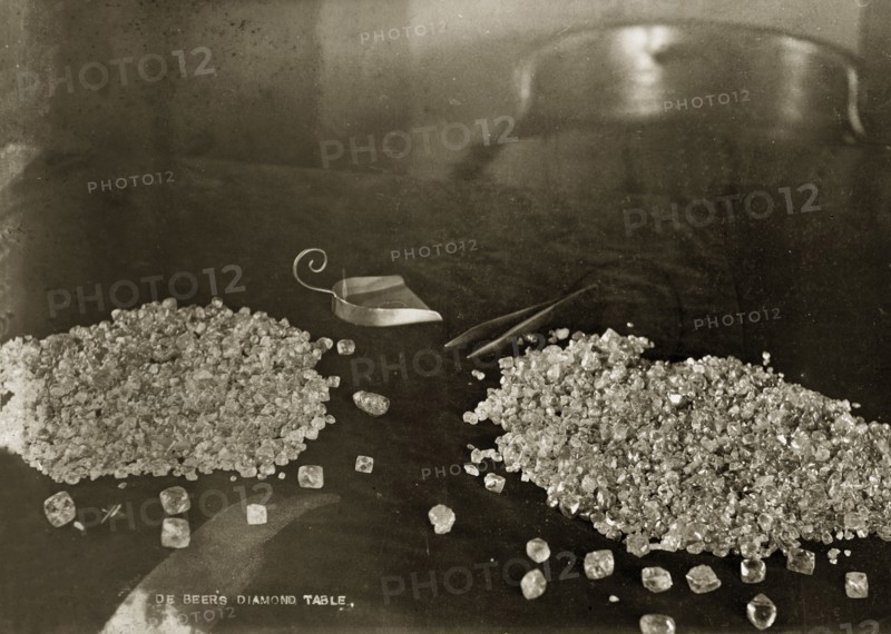 De Beers diamonds. Two piles of diamonds sit on a table at the De Beers offices in Kimberley, with a pair of tweezers and a scoop positioned beside them. Kimberley, South Africa, circa 1896. Kimberley, North Cape, South Africa, Southern Africa, Africa.