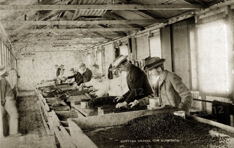 Sorting gravel for diamonds'. European workers at the De Beers diamond mine sift through trays of gravel looking for diamonds. Kimberley, South Africa, circa 1896. Kimberley, North Cape, South Africa, Southern Africa, Africa.