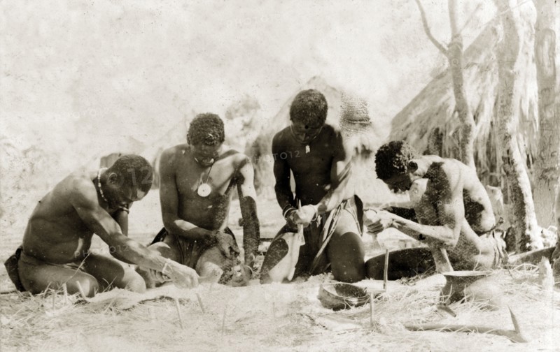 Tanners preparing a hide. Four tanners work on an animal hide that has been pegged to the ground, equipped with metal scrapers to remove hair from the skin. Rhodesia (Zimbabwe), circa 1897. Zimbabwe, Southern Africa, Africa.