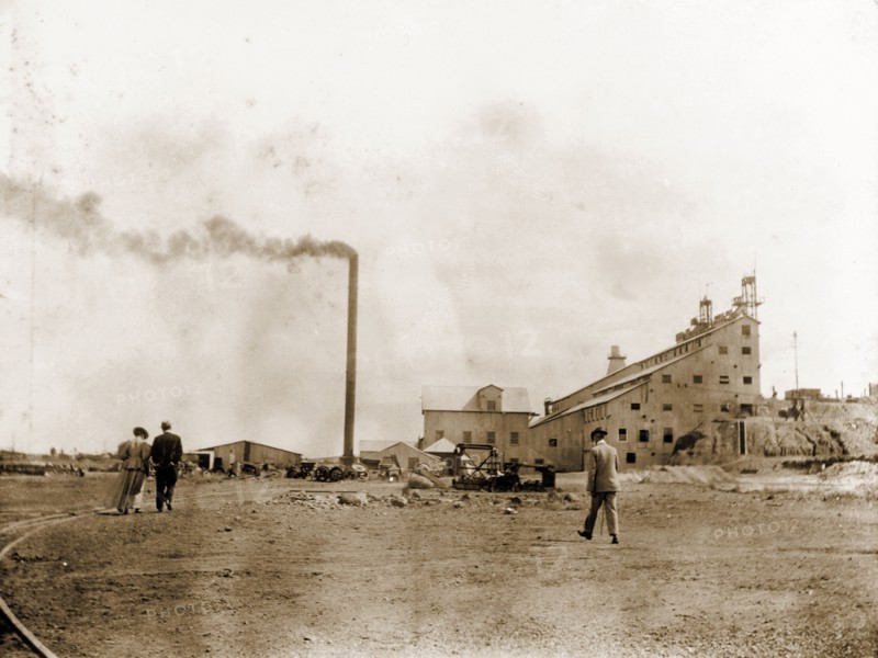 De Beers diamond mine in Kimberley. A tall, smoking chimney stands beside a factory building at the De Beers diamond mine in Kimberley. Kimberley, South Africa, circa 1896. Kimberley, North Cape, South Africa, Southern Africa, Africa.