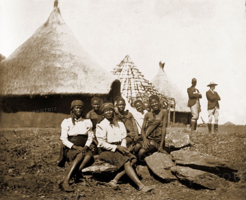 Matabele women at Cecil Rhodes' farm. A group of Matabele (Ndebele) women pose for the camera outside thatched huts at Cecil Rhodes' farm in Sauerdale. Rhodes bought the farm after negotiating an end to the Matabele rebellion, and settled some Matabele people there in part fulfilment of a promise to provide them with decent land. Near Bulawayo, Rhodesia (Matabeleland North, Zimbabwe), circa 1897., Matabeleland North, Zimbabwe, Southern Africa, Africa.