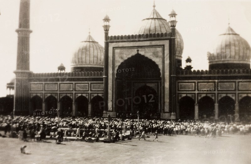 Friday prayers at the Jama Masjid, Delhi. A congregation of Muslim men gather outside Jama Masjid for 'Jumu'ah' (Friday prayer). The mosque was commissioned during the reign of Mughal Emperor Shah Jahan (r.1628-1658), and can accommodate up to 25,000 worshippers in its courtyard. Delhi, India, circa 1928. Delhi, Delhi, India, Southern Asia, Asia.