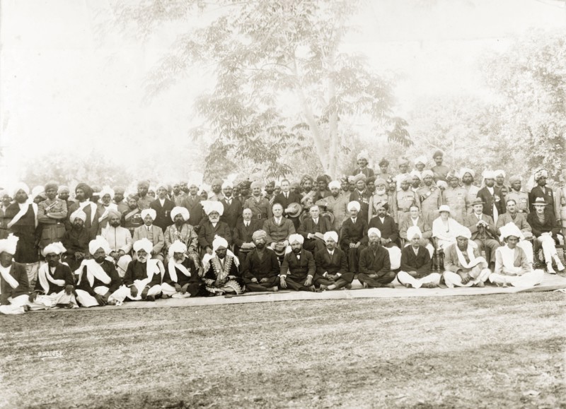 A garden party at Mianwali. Group portrait of a number of Indian officials, accompanied by eight European guests at a garden party. Related images suggest some of the men may be part of the 14th Sikh Regiment of the Indian Army. Mianwali, Punjab, India (Pakistan), 1920. Mianwali, Punjab, Pakistan, Southern Asia, Asia.