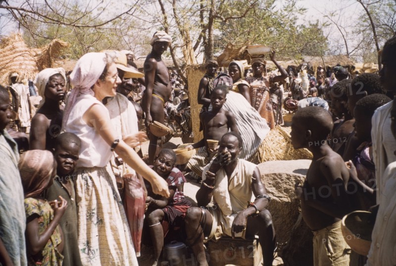 Joyce strikes a bargain. A British woman identified as 'Joyce', bargains with traders at a busy street market in Bolgatanga. Bolgatanga, Ghana, circa 1961. Bolgatanga, Upper East, Ghana, Western Africa, Africa.