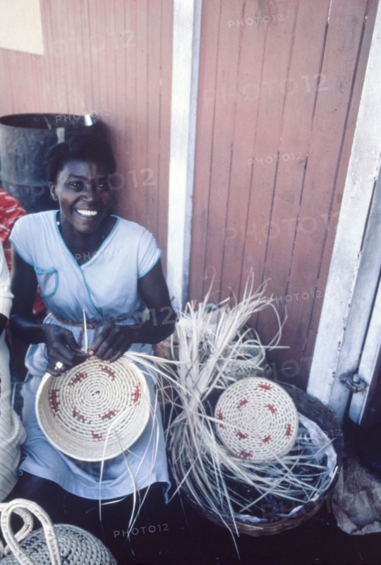 Weaving baskets, Jamaica. An official publicity shot for the Jamaican Tourist Board features a Jamaican craftswoman weaving patterned baskets. Jamaica, circa 1975. Jamaica, Caribbean, North America .