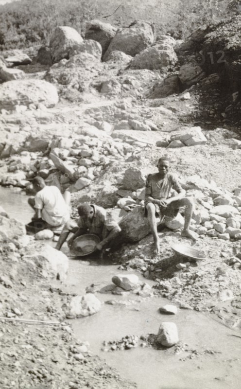 Panning for gold at Kakamega. African labourers pan for gold in the dried-up Wacheche River, located in the Kakamega goldfields. An original caption comments: "About an ounce a day, mainly in small nuggets, is extracted from this claim". Kakamega, Kenya, 1933. Kakamega, West (Kenya), Kenya, Eastern Africa, Africa.