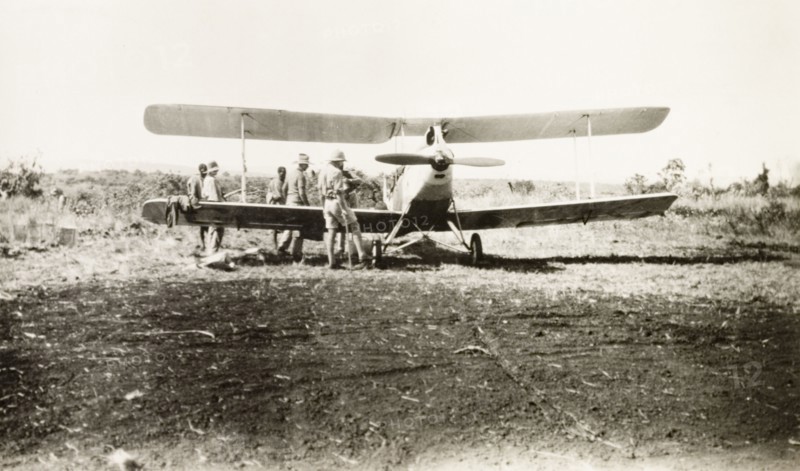 Light aircraft used to spot game. Several men surround a light aircraft used to spot game on safari. Tanganyika Territory (Tanzania), 1927. Tanzania, Eastern Africa, Africa.