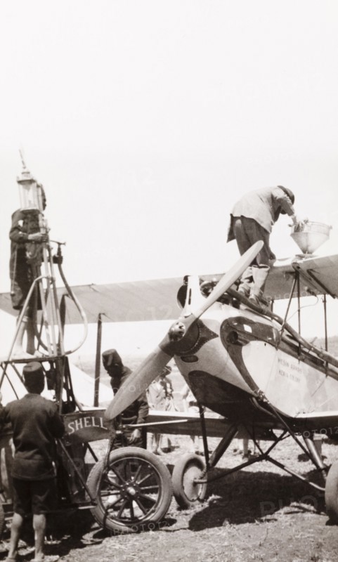 Refuelling an EAA aeroplane. Men refuel a East African Airways biplane at an airfield in Kenya. Kenya, circa 1930. Kenya, Eastern Africa, Africa.