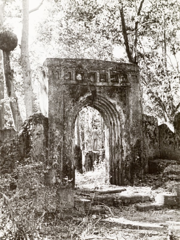 Arch at the ruins of Gedi. An arched stone doorway stands amidst the ruins of Gedi, an ancient Muslim town that was abandoned in the 17th century. The settlement featured a mosque, a palace and several large stone houses, and is thought to have been populated by around 2,500 people. Gedi (Gede), Coastal Region, Kenya, 1933. Gede, Coast, Kenya, Eastern Africa, Africa.
