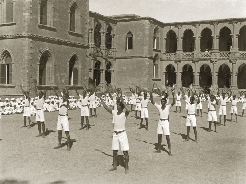 Exercises at Gordon College. African students exercise in an outdoor courtyard during an inspection visit by Sir Rudolf Carl von Slatin. The students wear matching uniforms of T-shirts and shorts, and stand in regimented rows with their hands held in the air. Khartoum, Sudan, 1926. Khartoum, Khartoum, Sudan, Eastern Africa, Africa.