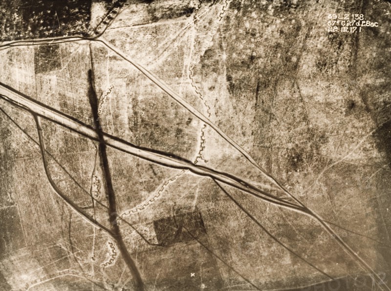 Aerial view of a battlefield under snow. One of a series of British aerial reconnaissance photographs recording the positions of trenches on the Western Front during the First World War. An original caption indicates the position of a British Field Battery Company, marked by a line of black dots in the top left hand corner. A strongly fortified trench zig-zags its way north to south, crossed by the dark lines of transport tracks. Nord-Pas de Calais or Picardie, France, 22 December 1917., Nord-Pas de Calais, France, Western Europe, Europe .