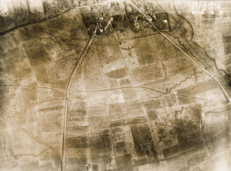 Aerial view of a bomb-damaged village. One of a series of British aerial reconnaissance photographs recording the positions of trenches on the Western Front during the First World War. Trenches zig-zag their way across fields pockmarked with bomb craters on the outskirts of a small village. An original caption indicates the position of a British Field Battery Company, located on a sunken road to the south. Nord-Pas de Calais or Picardie, France, 21 February 1918., Nord-Pas de Calais, France, Western Europe, Europe .