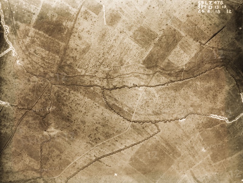 Aerial view of a front line system. One of a series of British aerial reconnaissance photographs recording the positions of trenches on the Western Front during the First World War. Shell craters pepper the fields surrounding a front line trench, probably British, which runs west to east. An original caption identifies the area to the north as no man's land. Nord-Pas de Calais or Picardie, France, 26 February 1918., Nord-Pas de Calais, France, Western Europe, Europe .