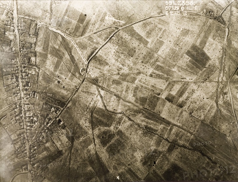 Aerial view of a bomb-damaged village. One of a series of British aerial reconnaissance photographs recording the positions of trenches on the Western Front during the First World War. Trenches zig-zag their way across fields pockmarked with bomb craters on the outskirts of a small village. Nord-Pas de Calais or Picardie, France, 2 February 1918., Nord-Pas de Calais, France, Western Europe, Europe .