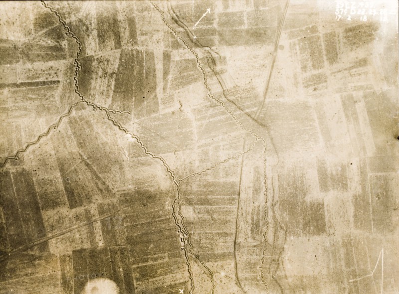 A front line trench on the Western Front. One of a series of British aerial reconnaissance photographs recording the positions of trenches on the Western Front during the First World War. A north-facing front line trench, probably British, is protected by a dark belt of barbed wire. The surrounding fields are pockmarked with bomb craters from a continuous barrage of artillery fire. Nord-Pas de Calais or Picardie, France, 17 February 1918., Nord-Pas de Calais, France, Western Europe, Europe .