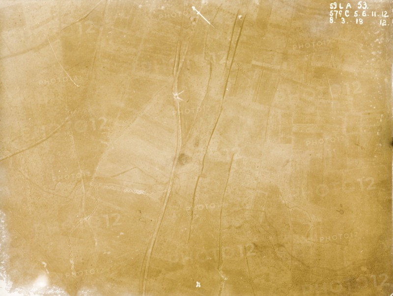 A mined road on the Western Front. One of a series of British aerial reconnaissance photographs recording the positions of trenches on the Western Front during the First World War. A small white circle on a main road running northeast to southwest indicates the explosion point of a mine. Several interconnecting trenches zig-zag their way across a patchwork of fields. Nord-Pas de Calais or Picardie, France, 8 March 1918., Nord-Pas de Calais, France, Western Europe, Europe .