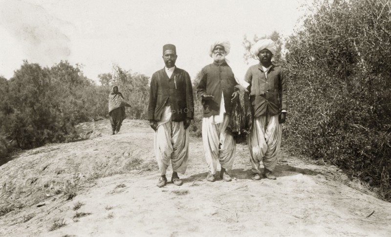 Khan Laghari with his two sons. An elderly Indian man, identified as Khan Laghari, walks along a rural road with his two sons. All wear traditional Indian dress including 'dhotis' and turbans. Probably Sind, India (Sindh, Pakistan), circa 1910., Sindh, Pakistan, Southern Asia, Asia.
