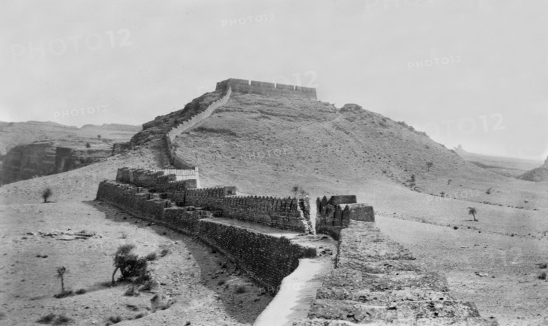 Fort wall in Kohistan . The defensive outer wall of a hill fort runs along the peak of a hill in Kohistan. Kohistan, North West Frontier Province, India (Pakistan), circa 1915. Kohistan, North West Frontier Province, Pakistan, Southern Asia, Asia.