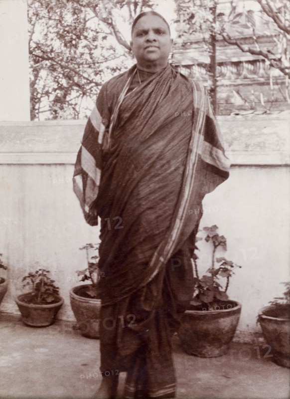 Portrait of an Indian man. An Indian man in traditional, possibly religious robes, poses outdoors beside a row of potted plants. Karachi, Sind, India (Sindh, Pakistan), circa 1910. Karachi, Sindh, Pakistan, Southern Asia, Asia.