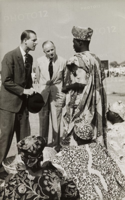 The Duke of Edinburgh visits Kaduna. The Duke of Edinburgh meets a group of young Nigerian men from Kaduna Children's Village during his visit to Nigeria with Queen Elizabeth II. The men demonstrate traditional basket-weaving skills outdoors, dressed in patterned robes and head wraps. Kaduna, Nigeria, February 1956. Kaduna, Kaduna, Nigeria, Western Africa, Africa.