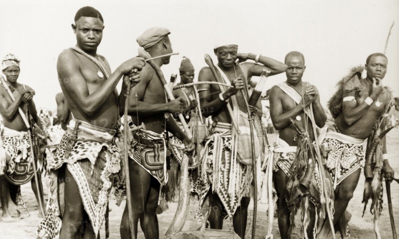 Nigerian hunters with bows and arrows. Portrait of a group of Nigerian hunters with bows and arrows. Naked from the waist up, they wear triangular pieces of cloth and animal skins around their waists. Nigeria, circa 1948. Nigeria, Western Africa, Africa.