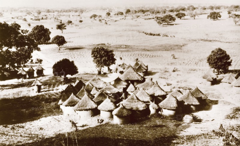 A Gwari village. A Gwari (Gbagi) settlement on the open plains, containing a cluster of round huts with mud walls and thatched roofs. Nigeria, circa 1940. Nigeria, Western Africa, Africa.