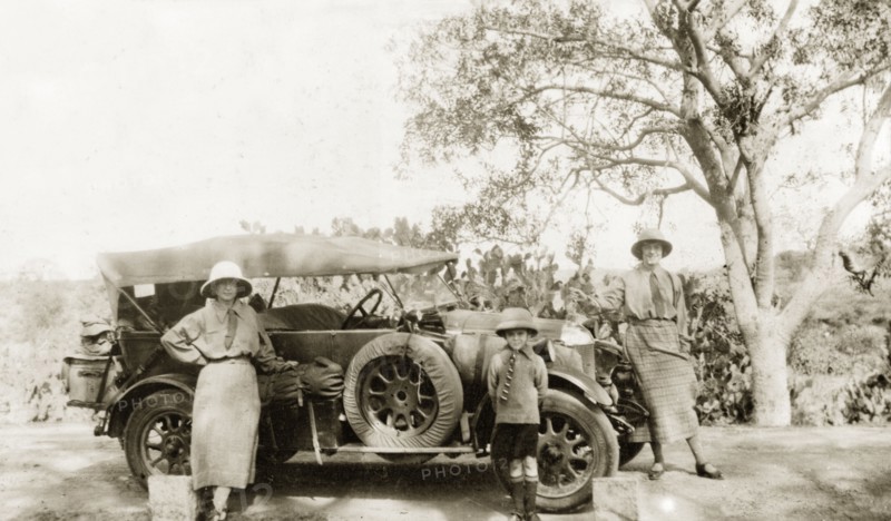 Preparing to embark on a journey. Two European women and a young boy pose beside a convertible car packed with luggage, ready to embark on a journey. India (Pakistan), circa 1930. Pakistan, Southern Asia, Asia.