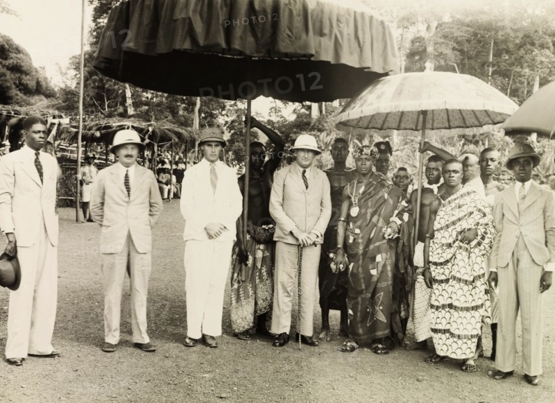 Sir Alan Burns at the Obuasi Durbar . British colonial administrators including Sir Alan Burns (1887-1980), Governor of the Gold Coast, pose for a group portrait with the Adansihene (Chief of Adansi) and his retinue, under ceremonial umbrellas at the Obuasi Durbar. Obuasi, Asante, Gold Coast (Ghana), 1943. Obuasi, Ashanti, Ghana, Western Africa, Africa.