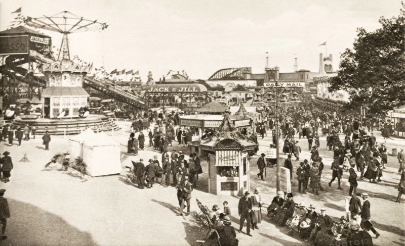 Fairground at British Empire Exhibition. Bustling crowds explore the fairground rides and stalls at the British Empire Exhibition at Wembley. London, England, 1924. London, London, City of, England (United Kingdom), Western Europe, Europe .