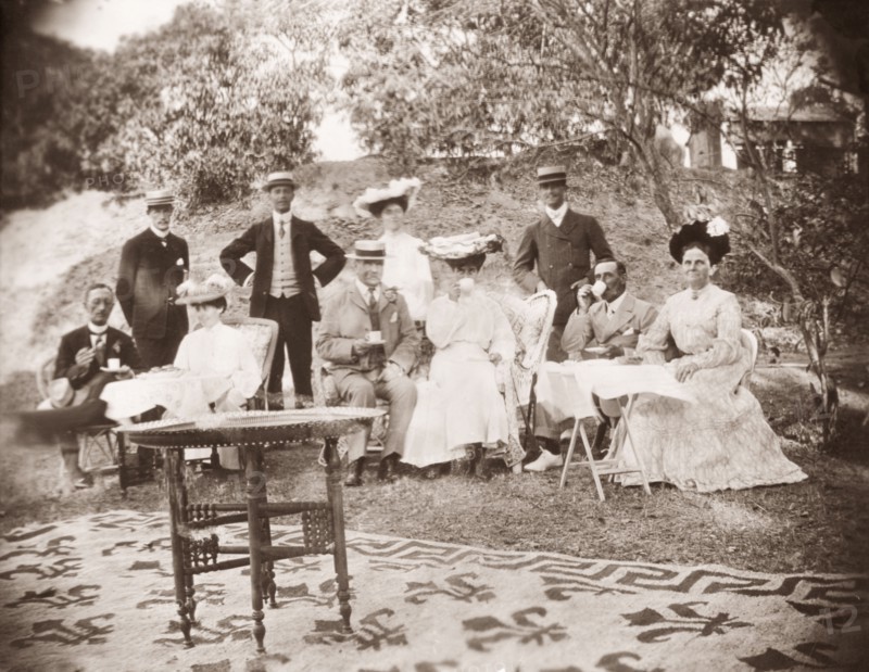 A Victorian picnic. A group of Victorian men and women drink cups of tea whilst picnicking in the gardens of Penshew House. Bangalore, India, circa 1900. Bangalore, Karnataka, India, Southern Asia, Asia.