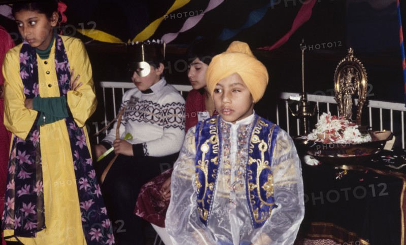 Boy in traditional Indian dress. A young turbaned boy in traditional Indian dress attends a cultural festival held at the Commonwealth Institute. London, England, circa 1985. London, London, City of, England (United Kingdom), Western Europe, Europe .