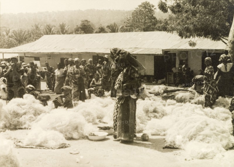 Fishing nets at a Ghanaian market. A street trader sells fishing nets at a marketplace near the Volta River. Volta Region, Gold Coast (Ghana), circa 1950., Volta, Ghana, Western Africa, Africa.