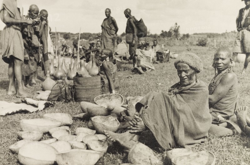 Calabashes on sale at a Kikuyu market. Customers peruse a selection of gourds and calabashes for sale at a Kikuyu market. Nyeri, Kenya, circa 1935. Nyeri, Central (Kenya), Kenya, Eastern Africa, Africa.