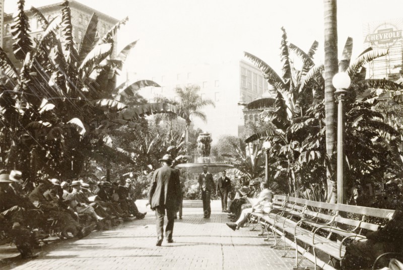 Pershing Square, Los Angeles. View along a tree-lined avenue leading to a decorative water fountain in Pershing Square, where visitors sit and relax on park benches. Los Angeles, United States of America, circa 1931. Los Angeles, California, United States of America, North America, North America .