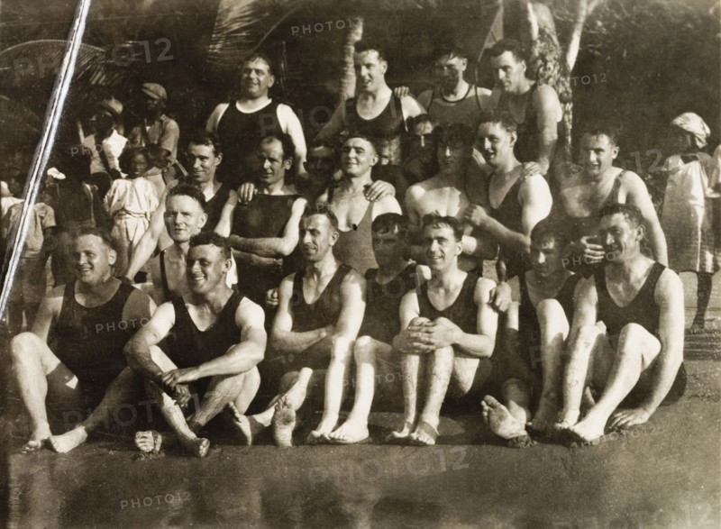 European bathers at Man-O-War Bay. A group of European bathers pose for a portrait in their swimwear on the beach at Man-O-War Bay. Related information suggests they are probably the crew of the Royal Navy warship HMS Dauntless. Tobago, circa 1931., Trinidad and Tobago, Trinidad and Tobago, Caribbean, North America .