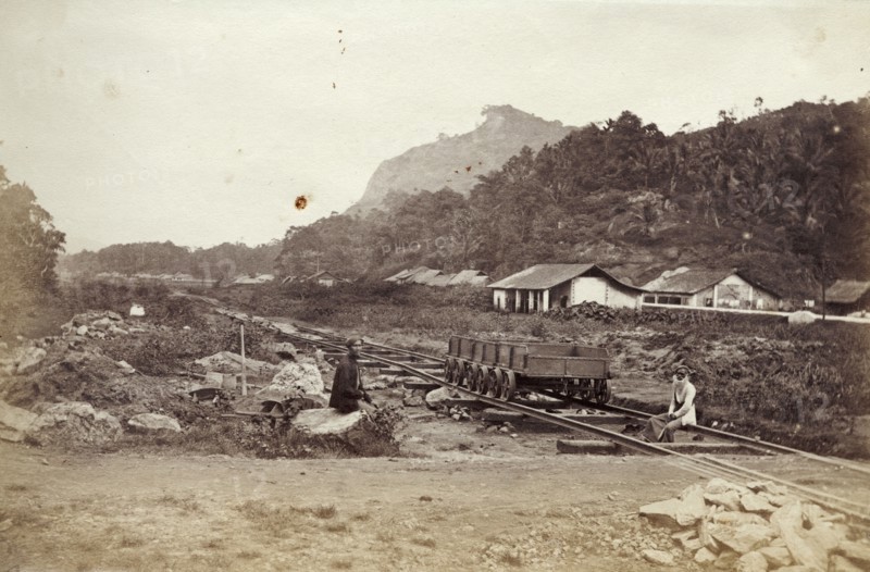 A Ceylon Government Railway track. Two men sit beside an empty rail cart on tracks belonging to the Ceylon Government Railway. Ceylon (Sri Lanka), circa 1865. Sri Lanka, Southern Asia, Asia.