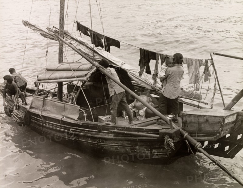 A Chinese family afloat. A Chinese family with three young children travel aboard a domestic sampan. An original caption comments that the "people in these craft(s) have no other home. In them they are born, live, marry and die. As fish are always plentiful no one goes hungry and there is no abject poverty here". Aberdeen, Hong Kong, China, 1963. Hong Kong, Hong Kong, China, People's Republic of, Eastern Asia, Asia.
