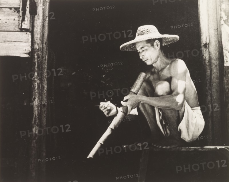 Smoking a bamboo pipe. A Chinese worker enjoys his bamboo pipe during a smoking break. Hong Kong, China, 1963. Hong Kong, Hong Kong, China, People's Republic of, Eastern Asia, Asia.
