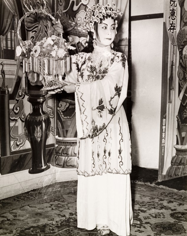 Portrait of a Chinese actress. An actress from a Chinese opera poses with a basket of flowers, wearing an embroidered costume, theatrical makeup and a decorative headpiece. Hong Kong, China, 1963., Hong Kong, China, People's Republic of, Eastern Asia, Asia.