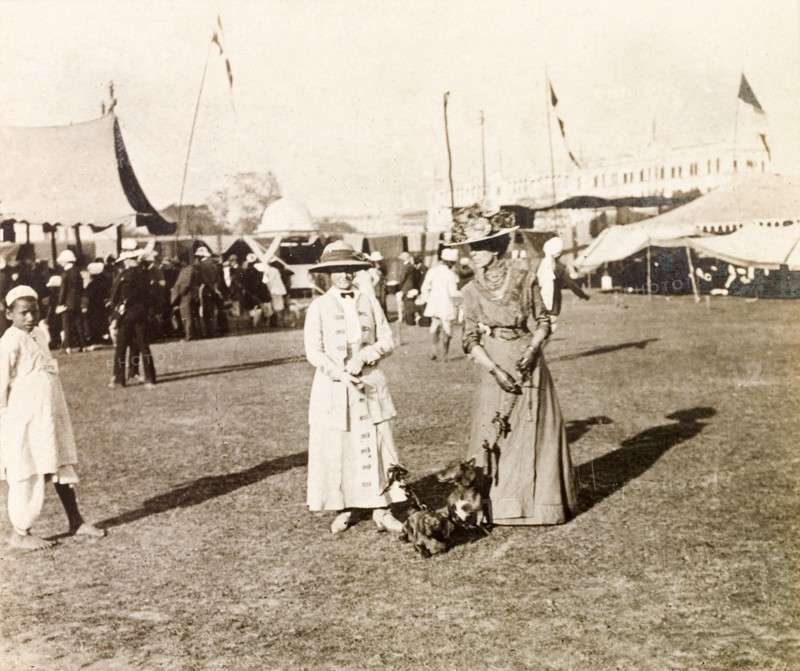 Women attending a dog show, Calcutta. Minnie Murray (left) and a friend, both elegantly dressed and wearing decorated, wide-brimmed hats, hold the leads of two prize-winning dachshunds, Hunden and Piper, at a dog show in Calcutta. Calcutta (Kolkata), India, 1912. Kolkata, West Bengal, India, Southern Asia, Asia.