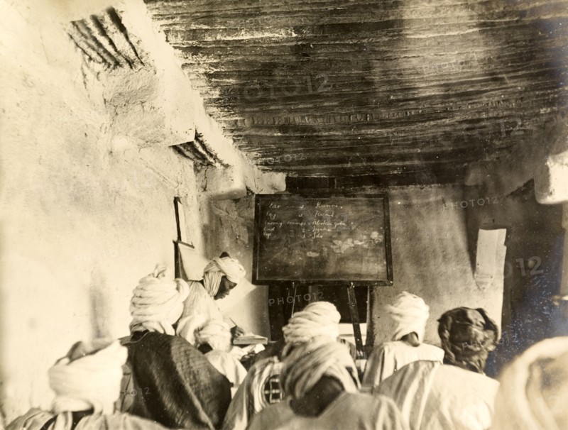 Adult students in a classroom, Kano. Adult students take notes from the blackboard during a lesson held inside a mud-walled classroom. Kano, Nigeria, circa 1914. Kano, Kano, Nigeria, Western Africa, Africa.