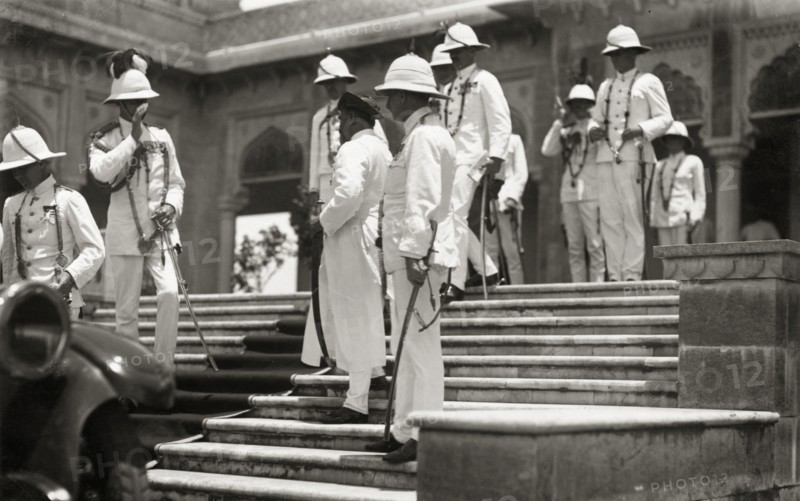 Viceregal entourage at Daly College. Officers of Lord Irwin's viceregal entourage, all in full dress uniform, wait on the steps of Daly College for the Viceroy to complete a guided tour of the college. Indore, Indore State (Madhya Pradesh), India, 31 July 1928. Indore, Madhya Pradesh, India, Southern Asia, Asia.