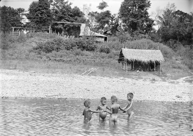 Children playing in water, Burma. Four young Burmese children stand in a circle holding hands as they play a game in the shallow water of a river. Burma (Myanmar), circa 1890. Burma (Myanmar), South East Asia, Asia.