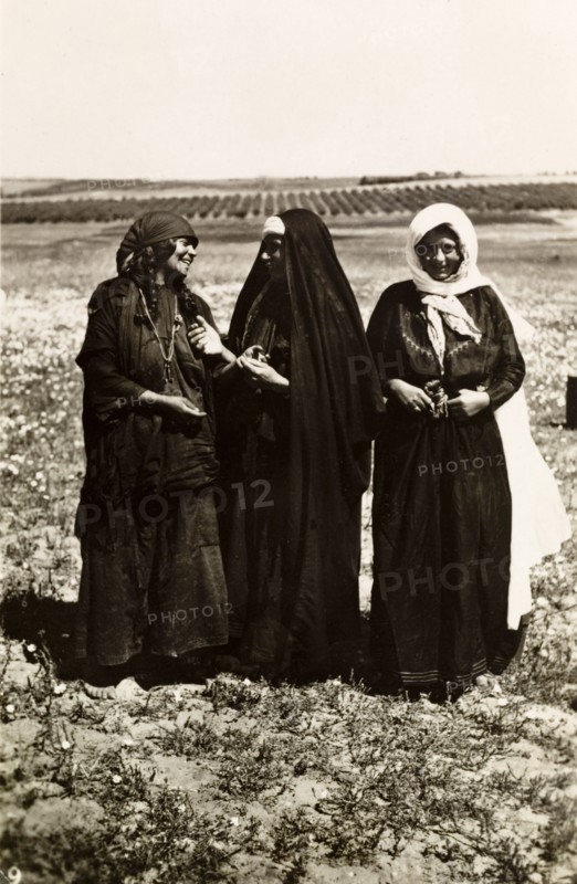 Palestinian bedouin women. Portrait of three Palestinian bedouin women standing in open countryside, two of whom are engaged in animated conversation. British Mandate of Palestine (Middle East), circa 1942., Middle East, Asia.