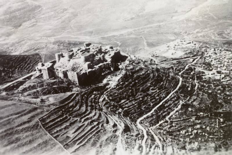 Castle overlooking a Palestinian settlement. An ancient castle with terraced ramparts sits atop a mountain, overlooking a Palestinian settlement in the valley below. British Mandate of Palestine (Middle East), circa 1938., Middle East, Asia.