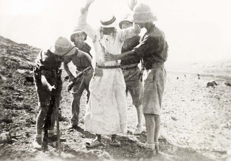 British soldiers searching a Palestinian Arab. Four British soldiers perform a body search on a Palestinian Arab detainee. During the period of the Great Uprising (1936-39), an additional 20,000 British troops were deployed to Palestine in an attempt to clamp down on Arab dissidence. British Mandate of Palestine (Middle East), circa 1938., Middle East, Asia.