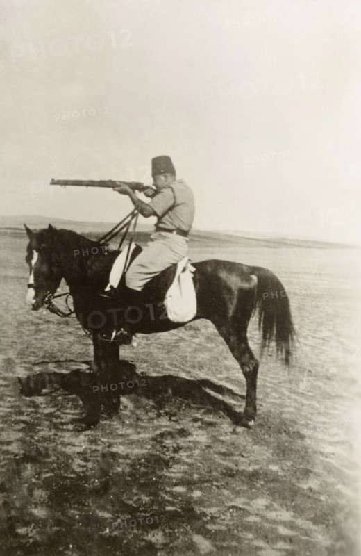 Arab officer of the Palestine Police Force. A mounted Arab officer of the Palestine Police Force takes aim with a rifle. British Mandate of Palestine (Middle East), circa 1938., Middle East, Asia.